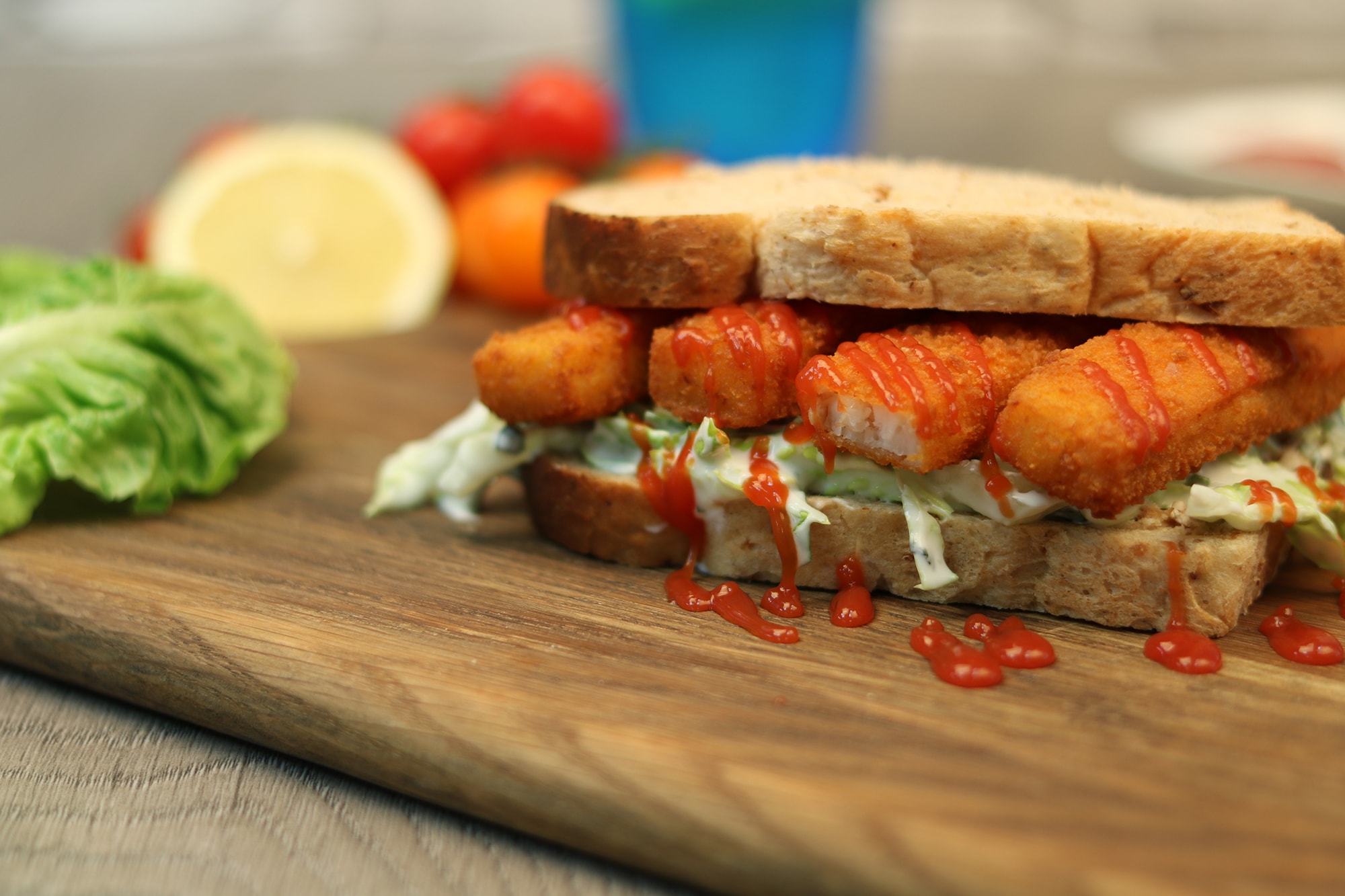 Fish finger sandwich with ketchup, lettuce and tartar sauce