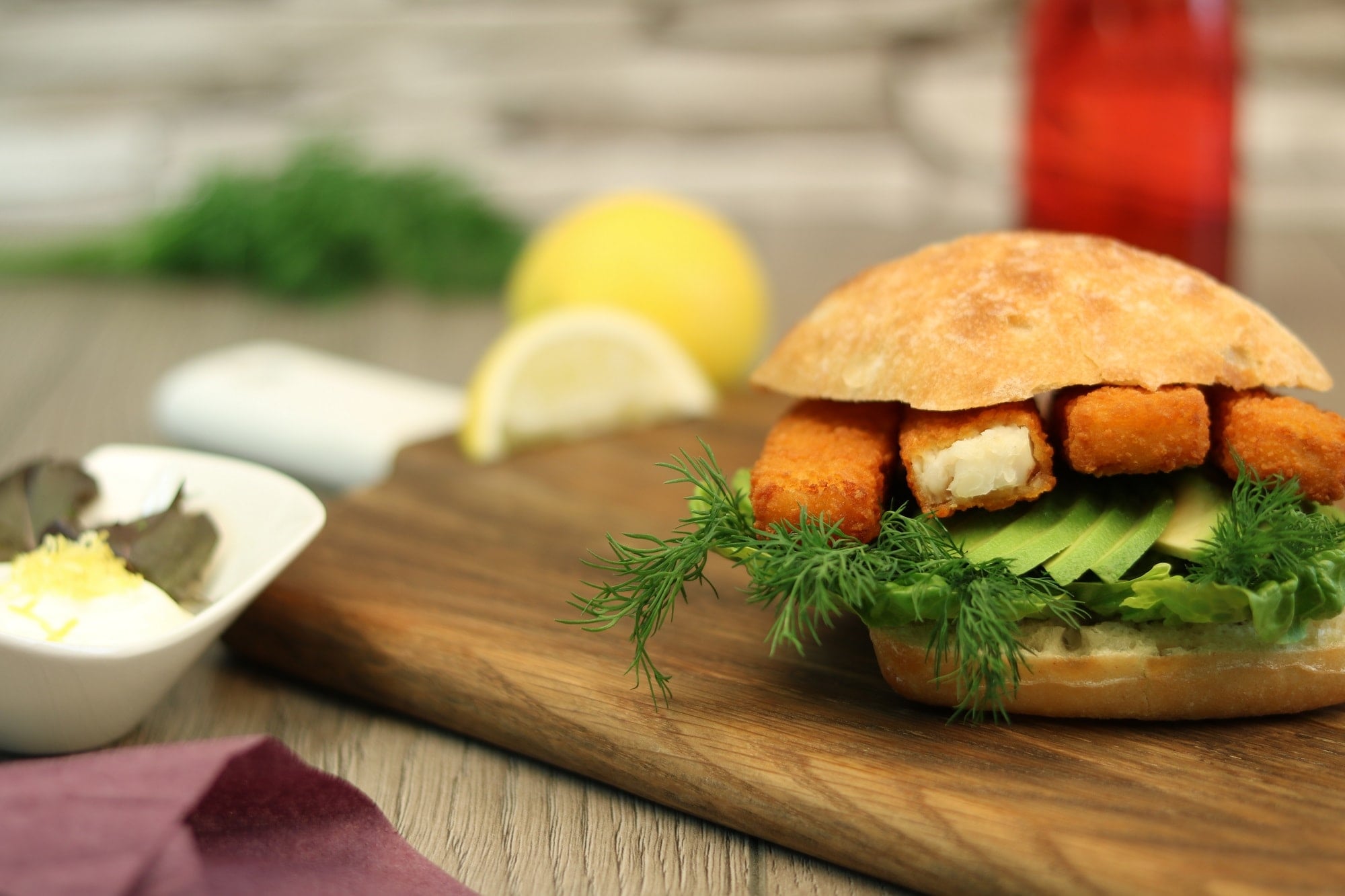 Fish fingers with avocado and dill in a ciabatta roll