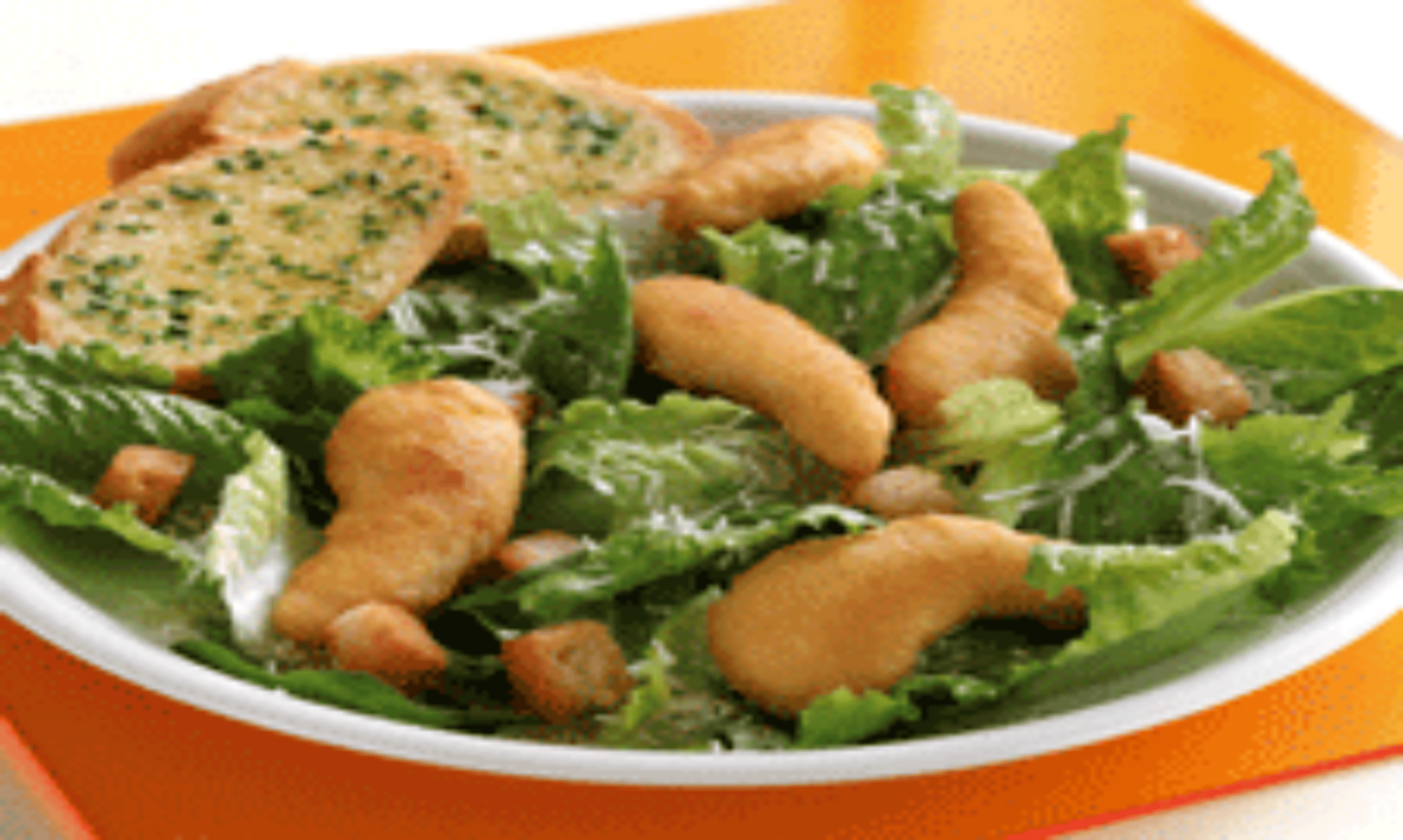 Caesar salad topped with chicken dippers