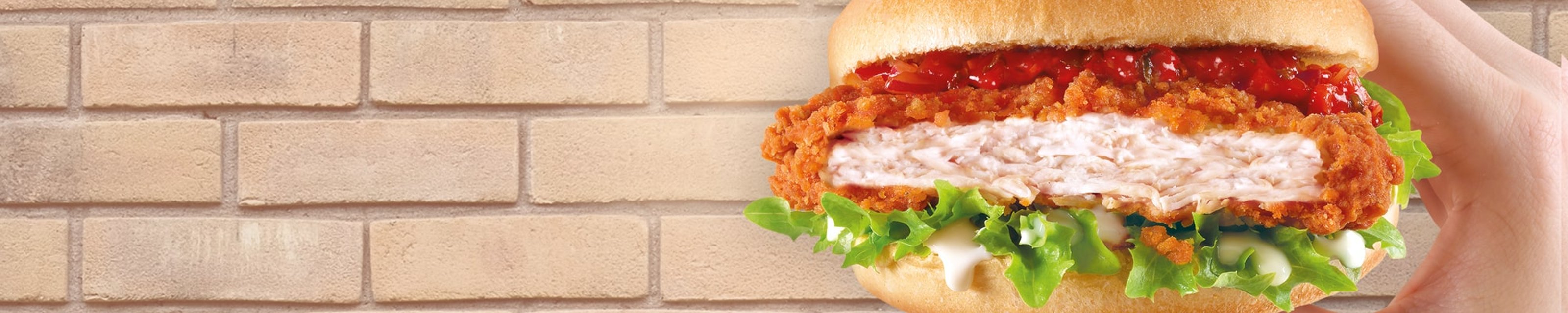Crispy chicken burger in a bun with lettuce and chilli relish