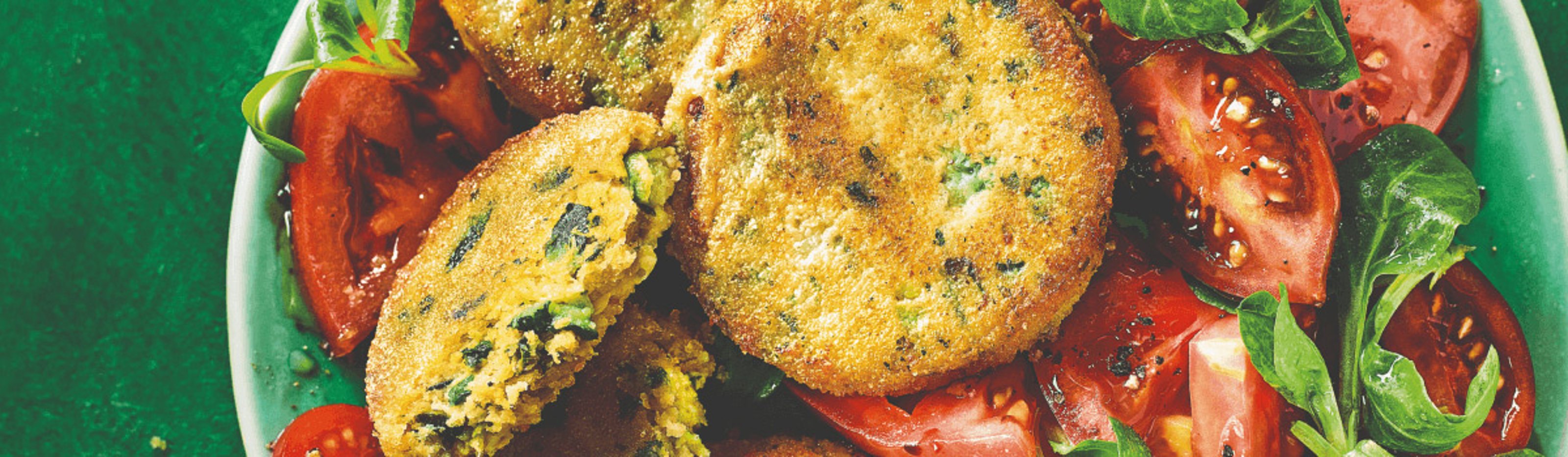 Breaded pea and vegetable patties on a tomato and lamb's lettuce salad